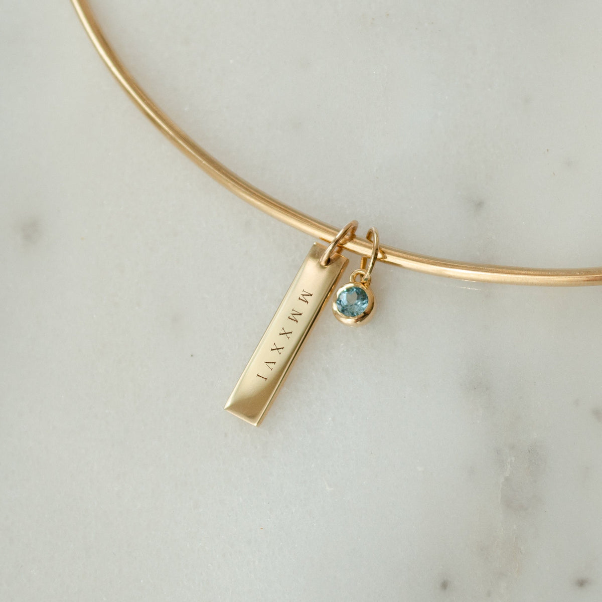 2026 Grad Layering Bar shown on Neck Collar with Blue Topaz Gemstone in gold