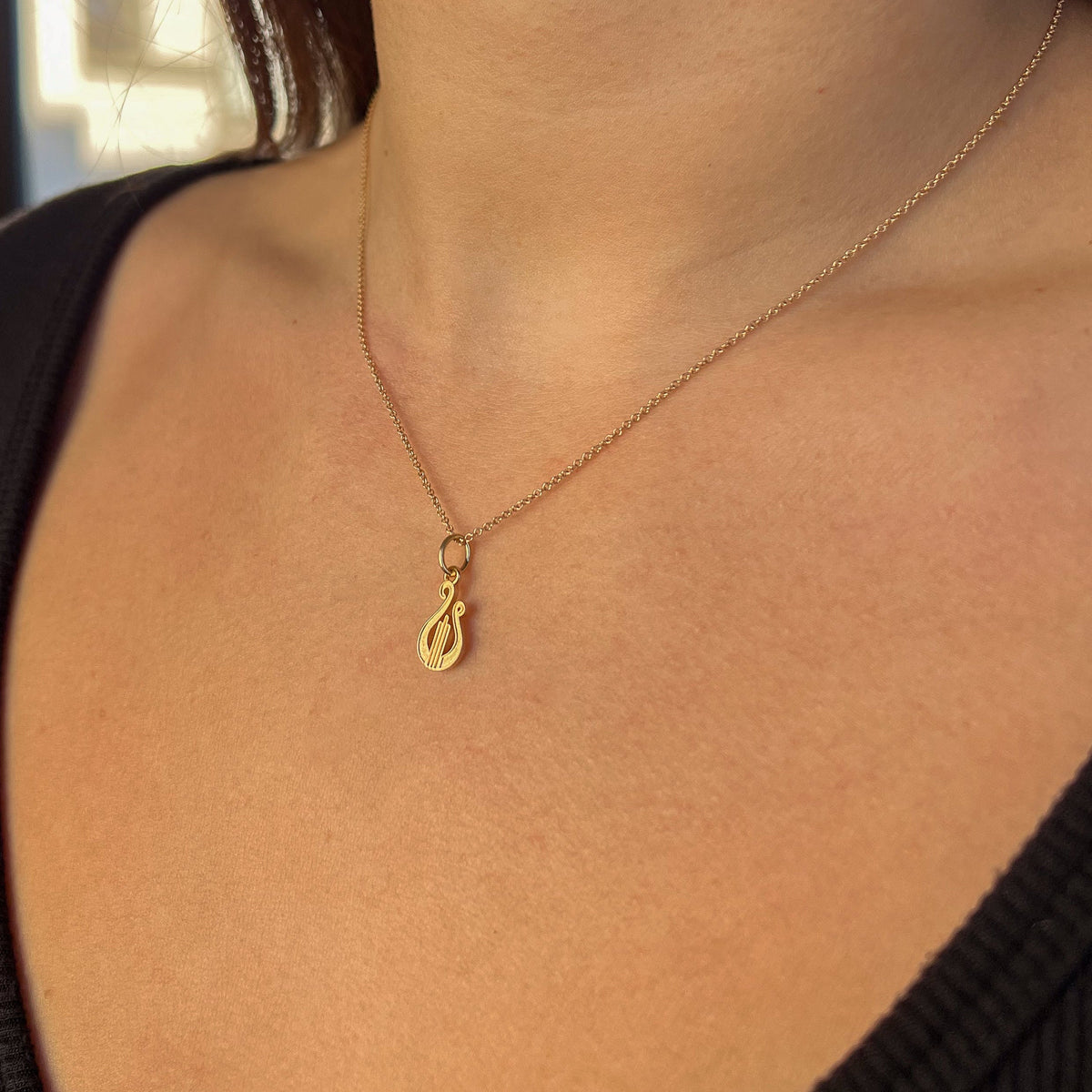 Alpha Chi Omega Lyre Charm shown on figure in gold on Cable Chain