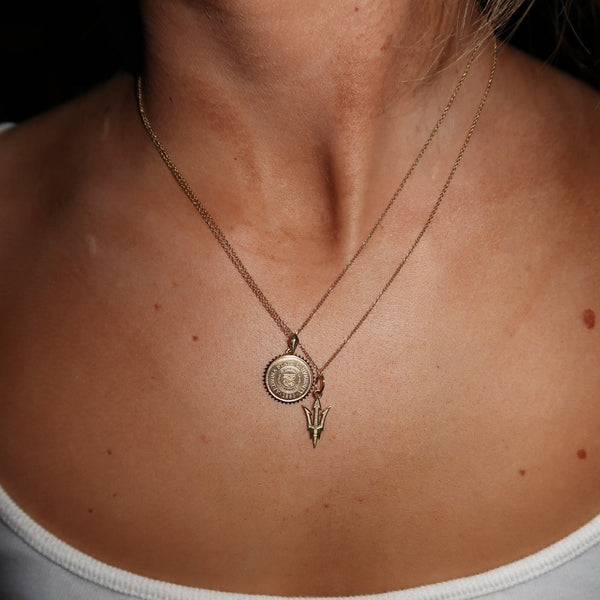 ASU Sunburst Pendant shown on figure in gold on Cable Chain with ASU Pitchfork Charm on Cable Chain