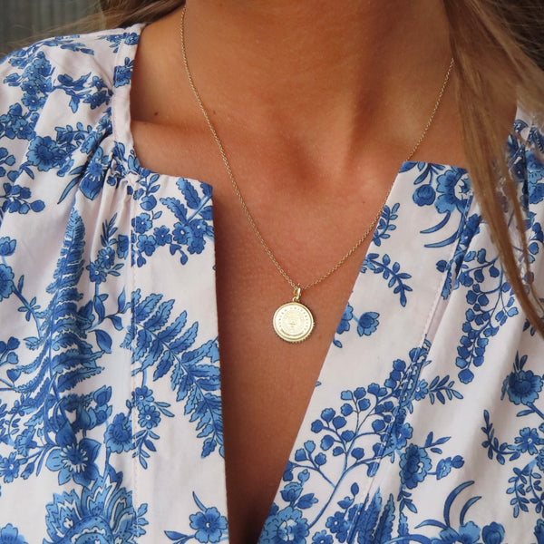 Auburn Sunburst Pendant shown on figure in gold on Cable Chain