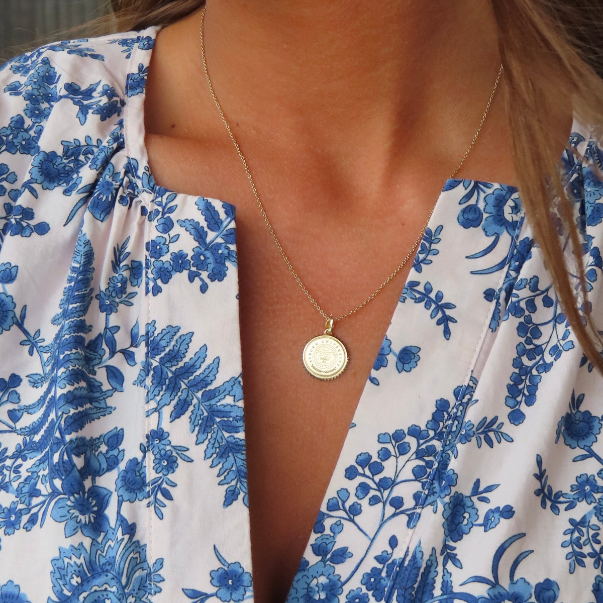 Auburn Sunburst Pendant shown on figure in gold on Cable Chain