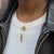 UT Tower Necklace shown on figure in gold with Texas Exes Sunburst and Link Chain Choker