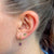 Kansas State Wildcat Studs shown on figure in gold with Amethyst Florentine Bundle