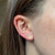 Alpha Chi Omega Lyre Stud Earring shown on figure in gold