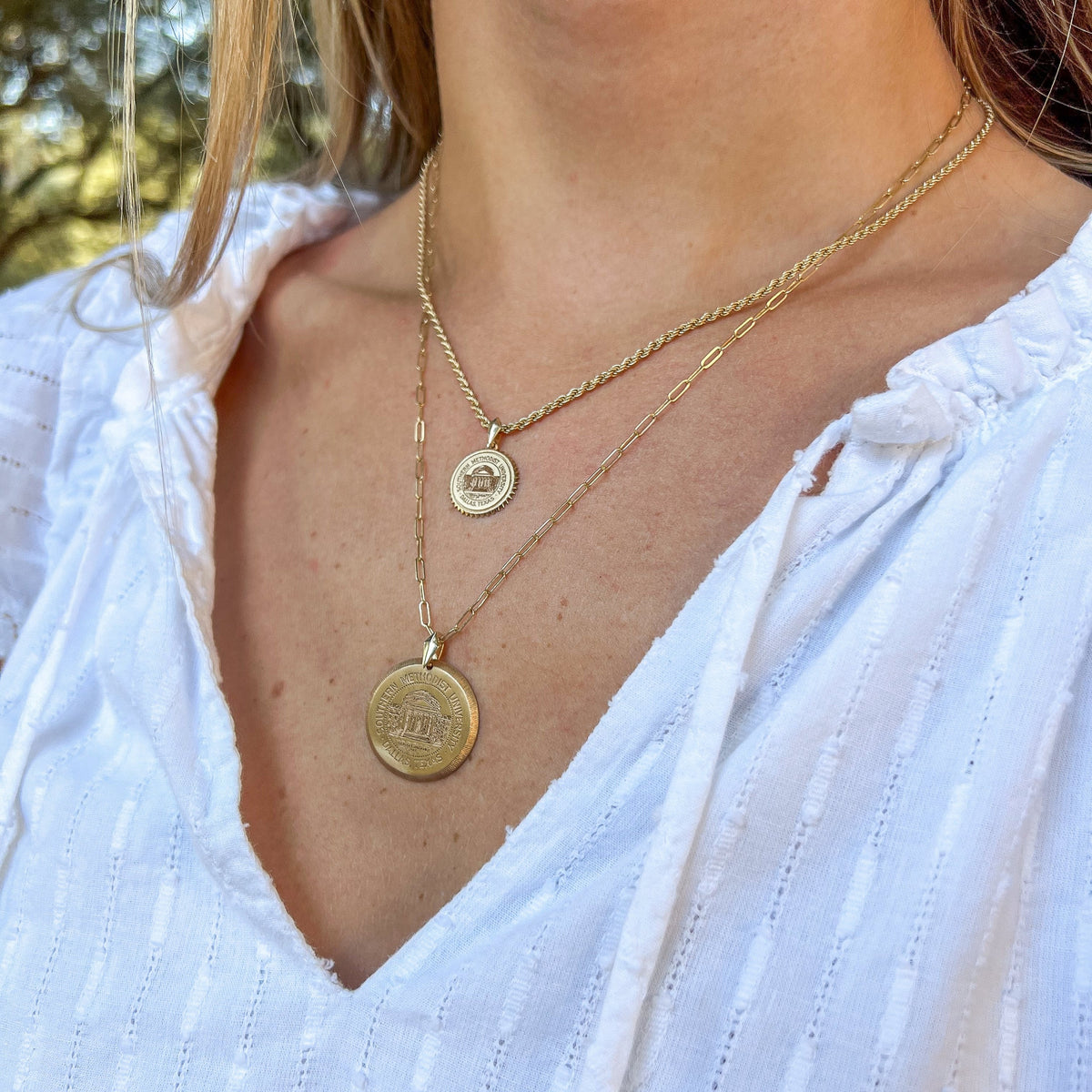 SMU Seal Sunburst Necklace shown on figure in gold with SMU Seal Florentine Necklace on Link Chain