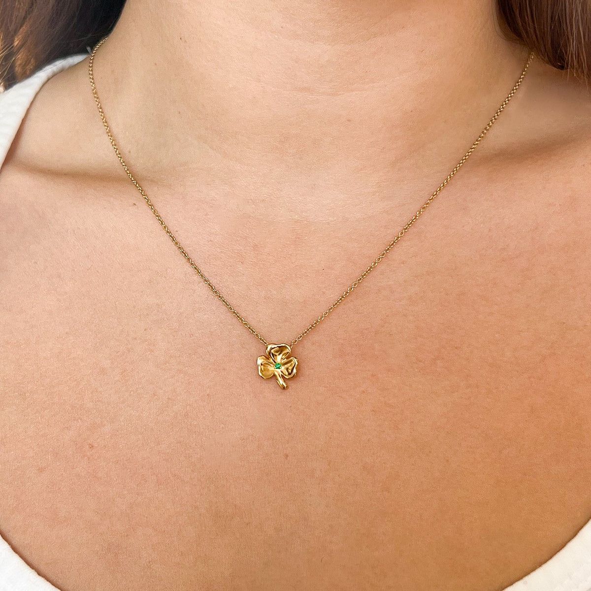 Emerald Shamrock Charm shown on figure in gold on Cable Chain