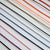 A close-up of multiple thin cords or threads arranged diagonally on a white background, shown in several colors including black, purple, pink, blue, green, orange, and red.
