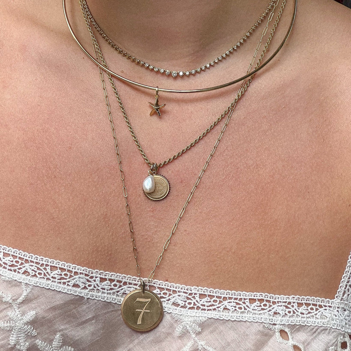 Pearl Charm shown on figure on Sunburst Pendant with Starfish Charm on Neck Collar