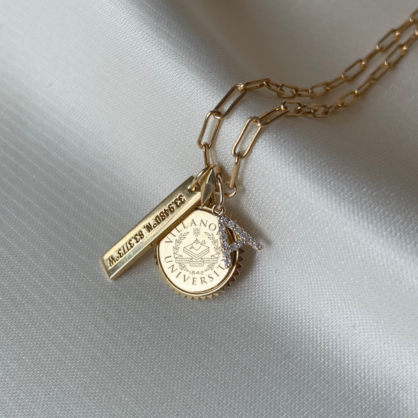 Villanova Sunburst Necklace shown in gold on Link Chain with Coordinates Bar and Diamond Letter Charm laydown