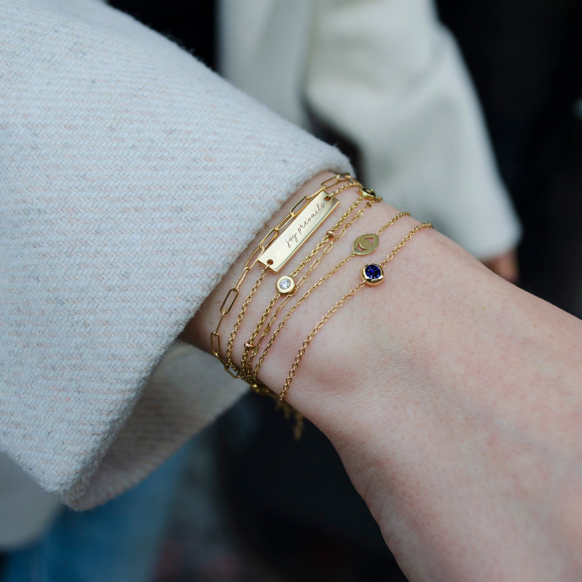 Kentucky DanceBlue "Joy Prevails" Bar Bracelet shown on figure in Cavan Gold with Large Link Chain Bracelet and Sapphire Bracelet