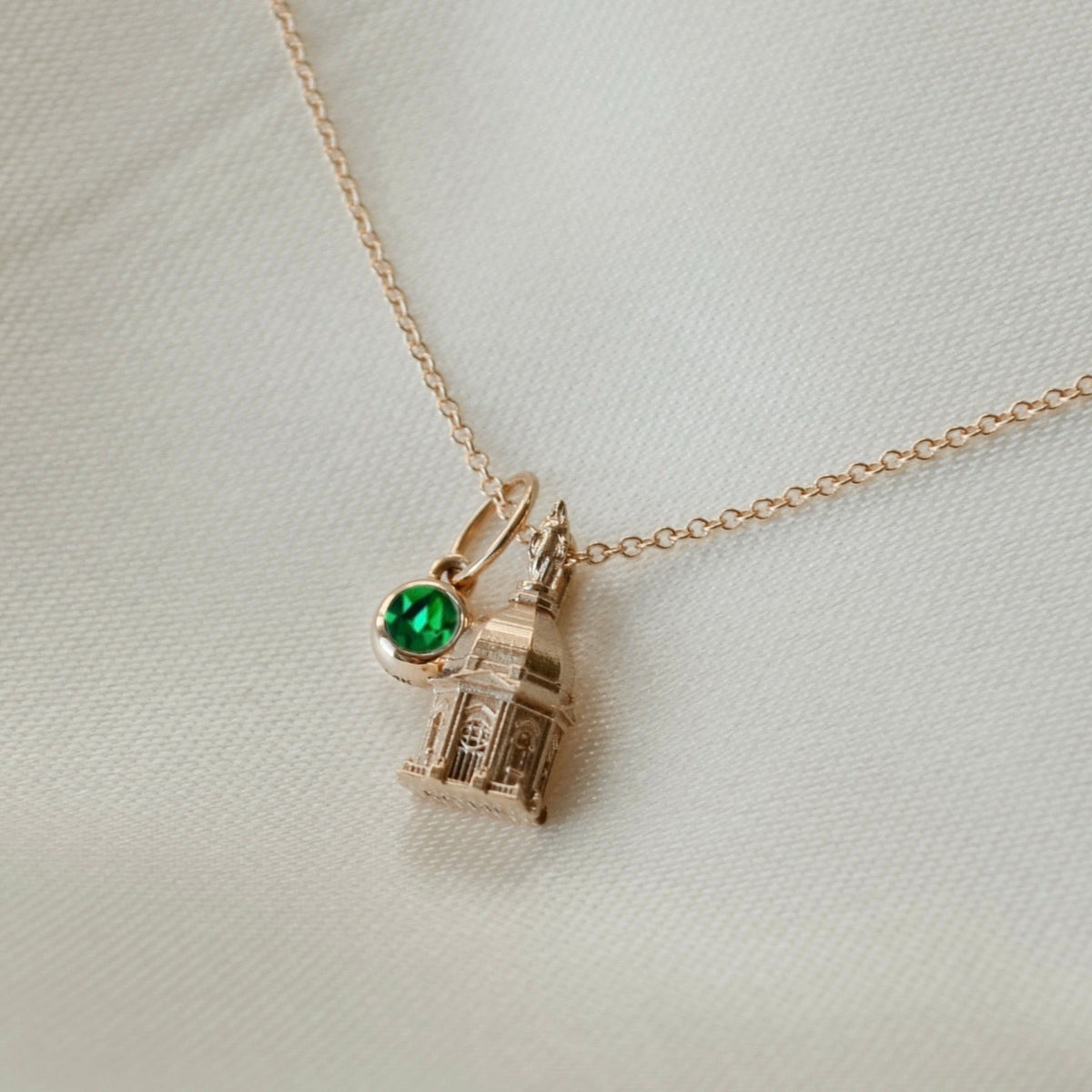 Notre Dame Golden Dome Pendant shown in gold on Cable Chain with Emerald Gemstone laydown