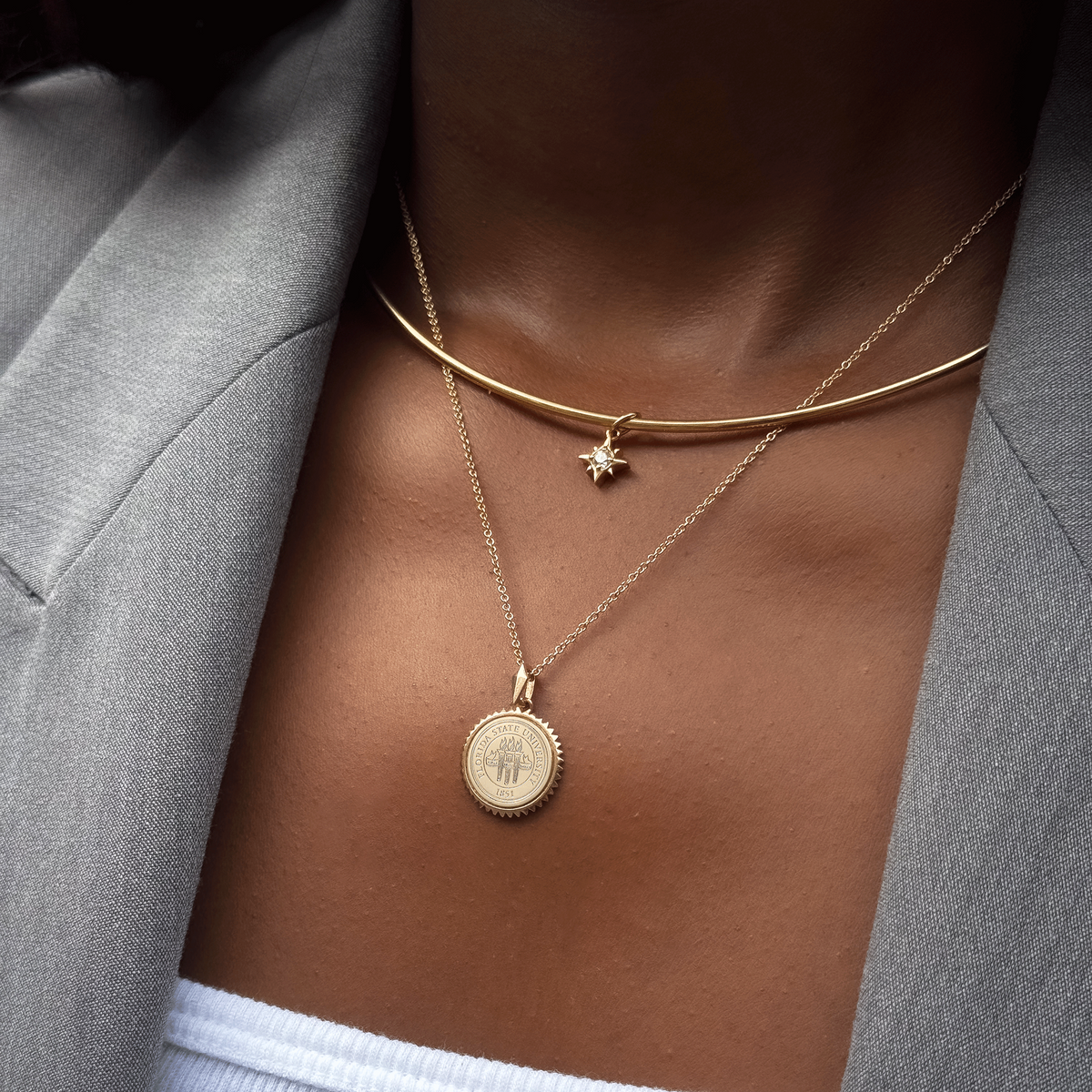 North Star Charm shown on figure in gold on Neck Collar with FSU Sunburst on Cable Chain