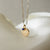 Duke University Seal Sunburst shown as a Sunburst Bundle on Link Chain with Sapphire Gemstone Charm in gold